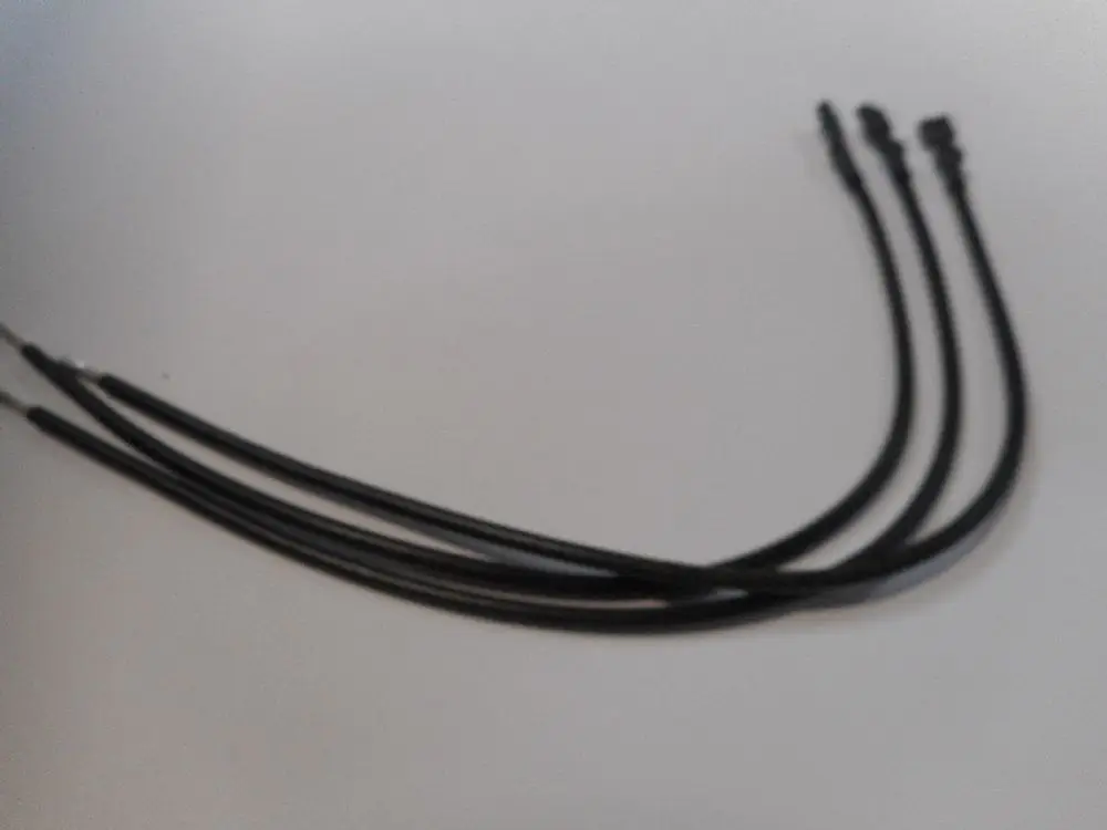 Drei schwarze Kabel mit unterschiedlichen Enden, wahrscheinlich zur Verbindung oder Steuerung von Geräten, erkennbar als Zubehör von Remeha.